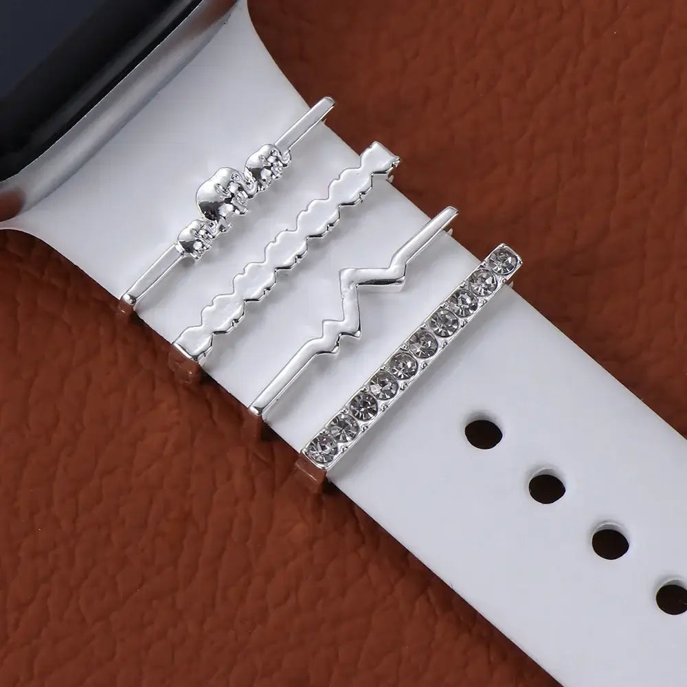 Decorative metal charms on a white Apple Watch band, showcasing elegant design and stylish sophistication.