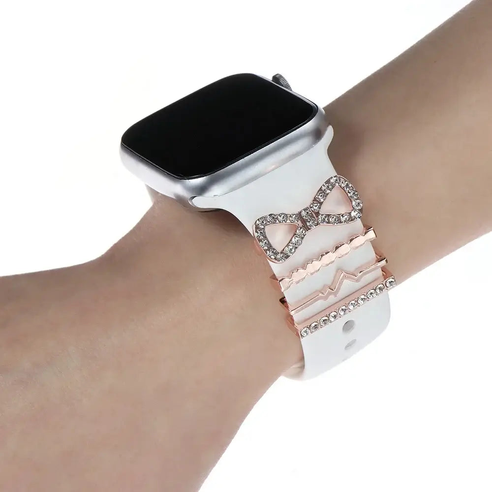 Decorative metal charms on a white Apple Watch band, enhancing style and sophistication for smartwatch wearers.