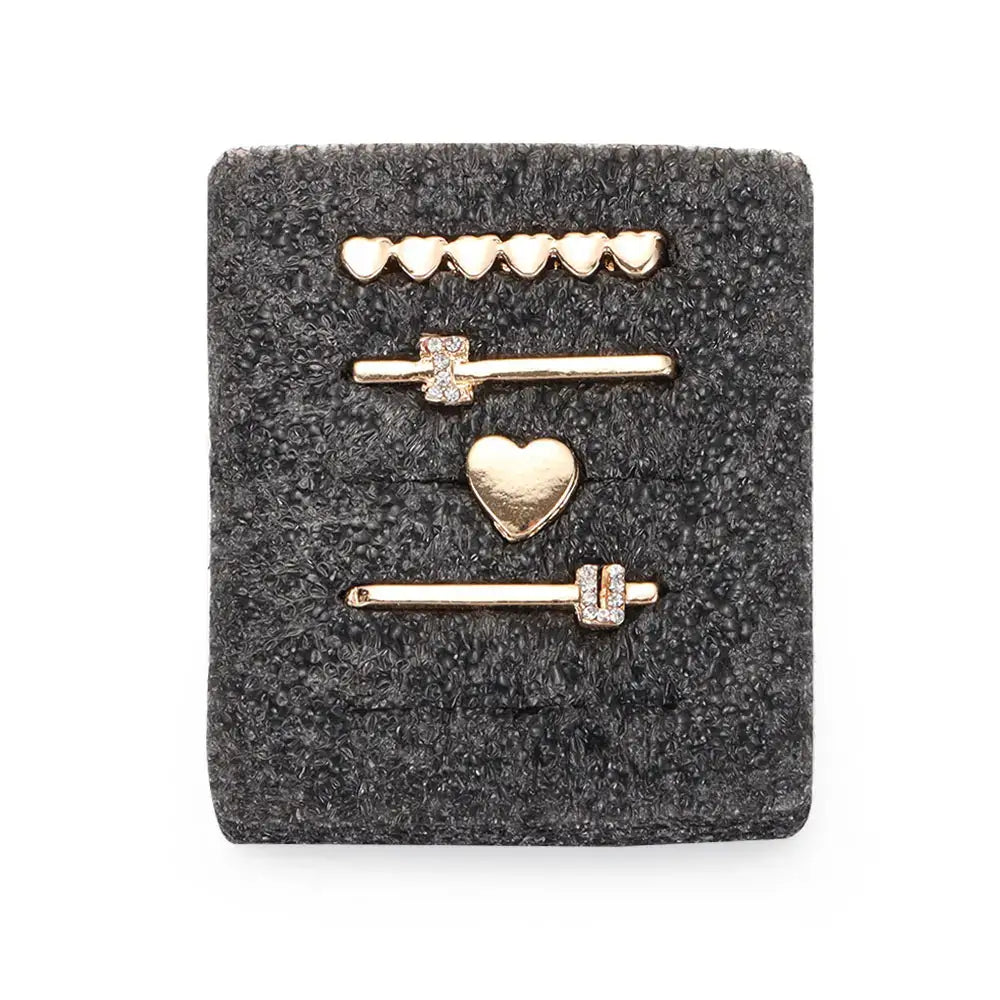 Decorative metal charms for Apple Watch bands featuring hearts and sparkly designs on a soft background.