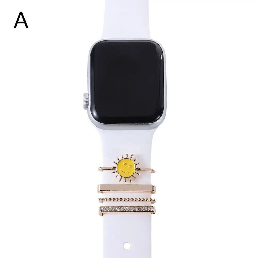 Decorative metal charms on a white Apple Watch band, featuring a cheerful sun design for stylish elegance.