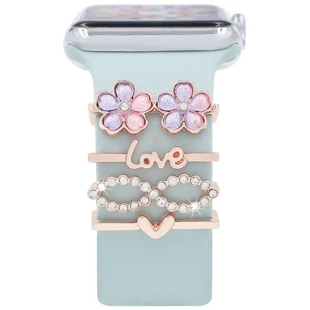 Decorative metal charms for Apple Bands featuring flowers, love symbol, and infinity design on a smartwatch.