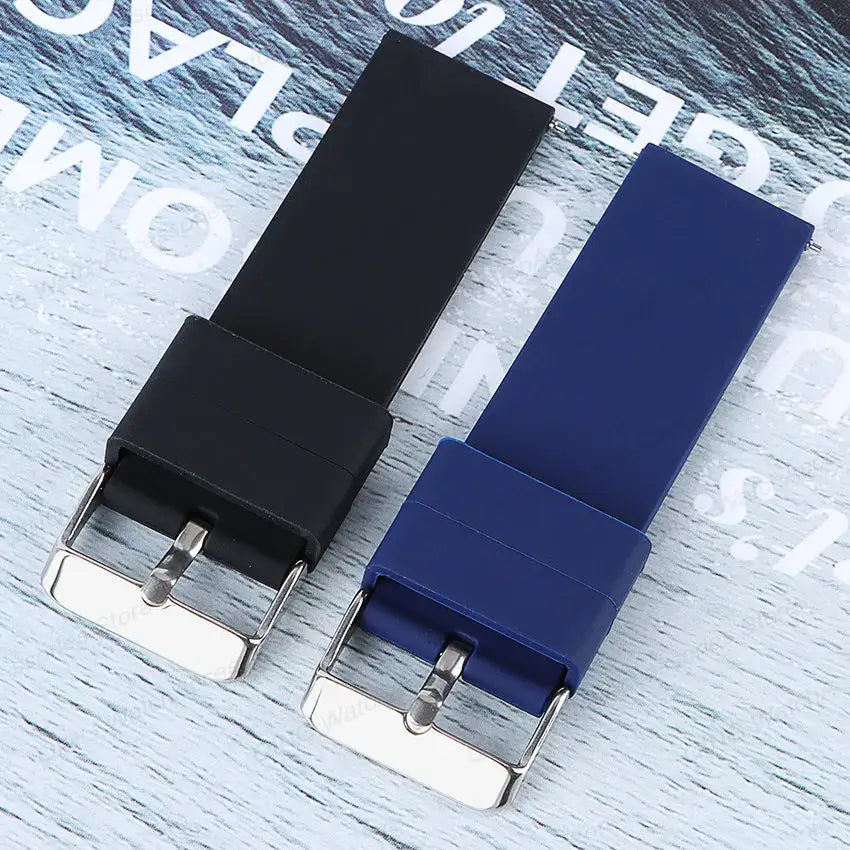 Black and blue silicone straps for Samsung Galaxy Watch with stainless steel buckles on a light wooden background.