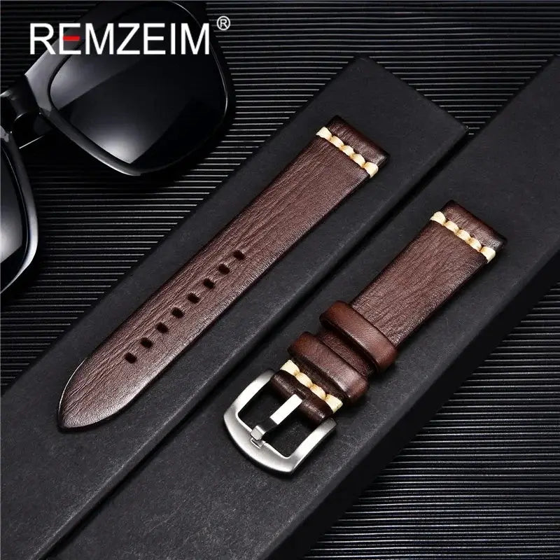 Stylish brown leather watch band with buckle, displayed with sunglasses in an elegant packaging. Perfect for any occasion.