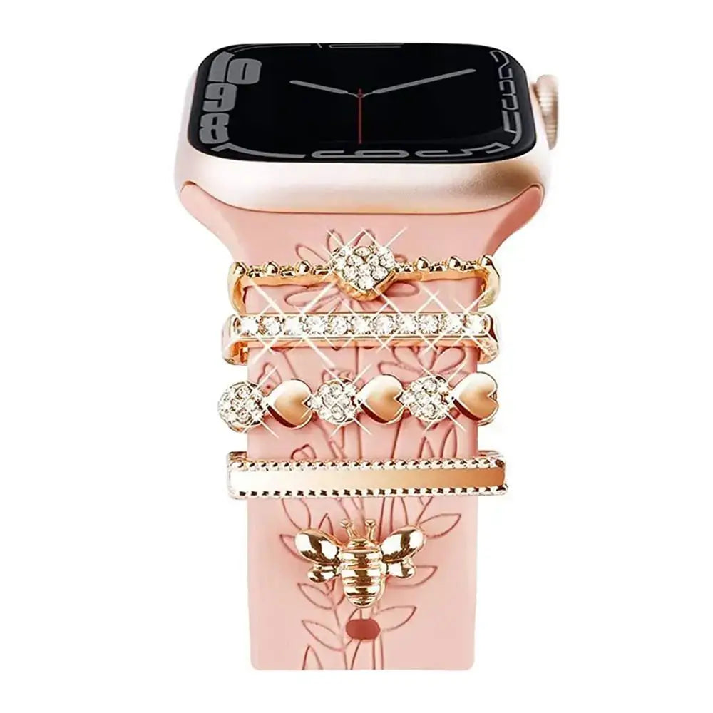 Decorative metal charms on a pink Apple Watch band, showcasing elegant design and stylish sophistication.