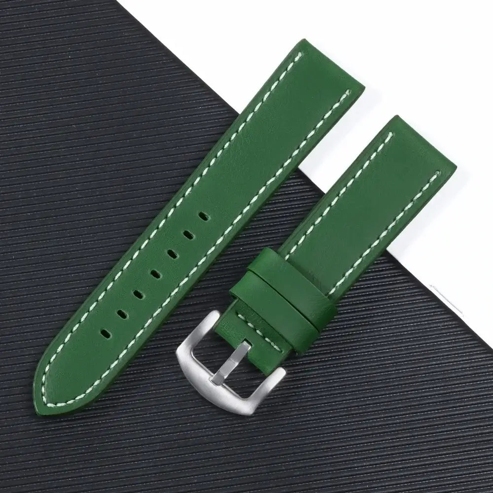 Green leather Suunto watch band with white stitching, featuring a silver buckle for a modern look.