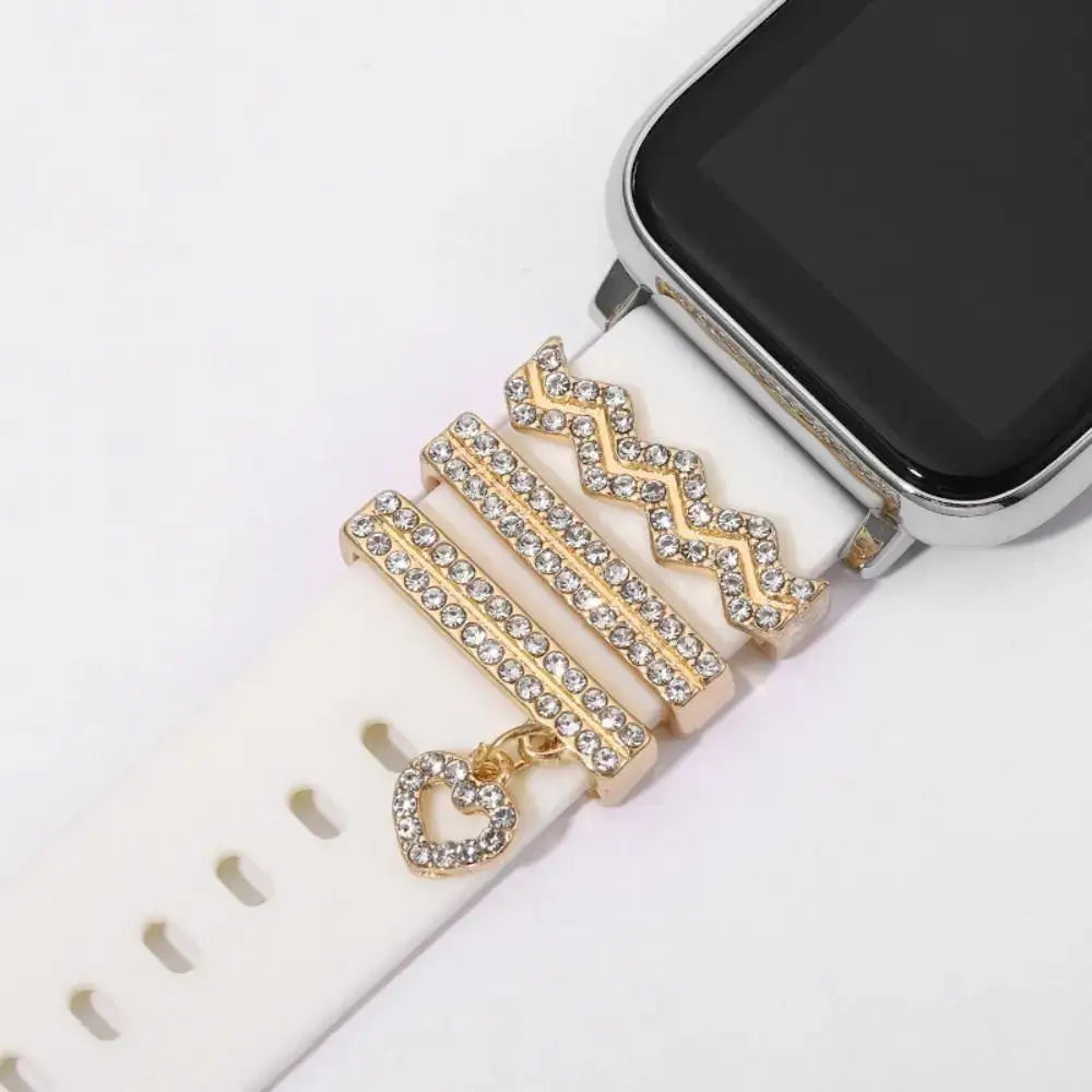 Decorative metal charms with rhinestones on a white Apple Watch band, enhancing style and sophistication.