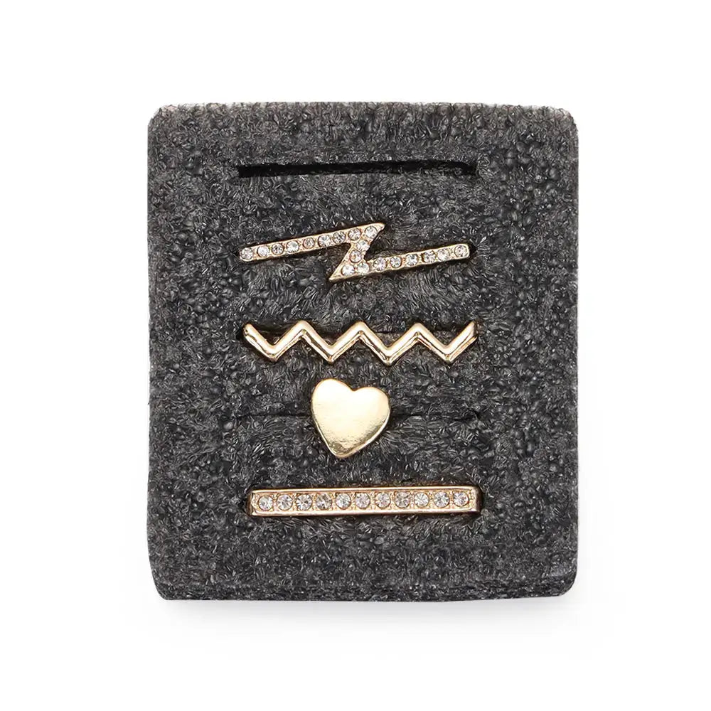 Decorative metal charms for Apple Watch bands featuring gold and crystal designs, including a heart and zigzag shapes.