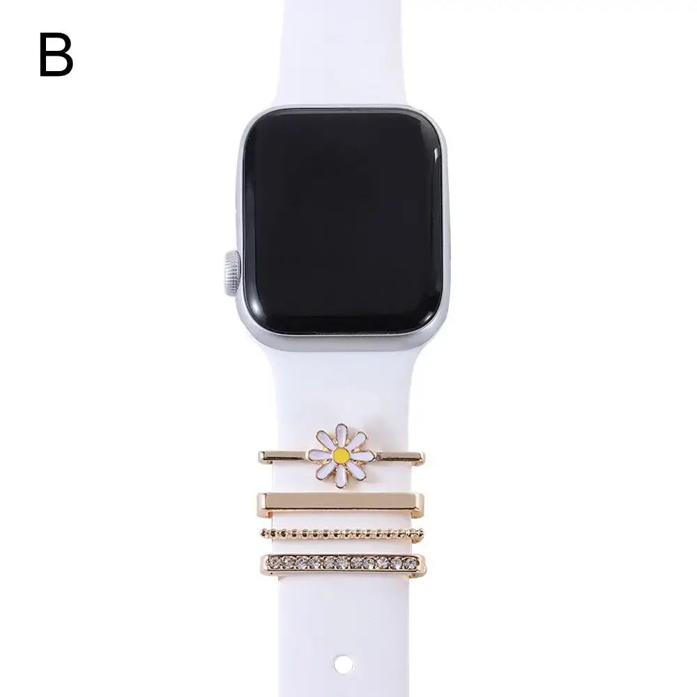 Decorative metal charms for Apple Watch featuring a daisy design and elegant gold accents on a white band.