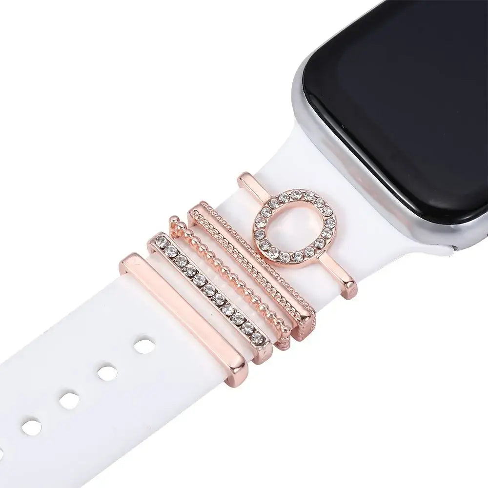 Decorative rose gold charms on a white Apple Watch band, enhancing smartwatch style and elegance.