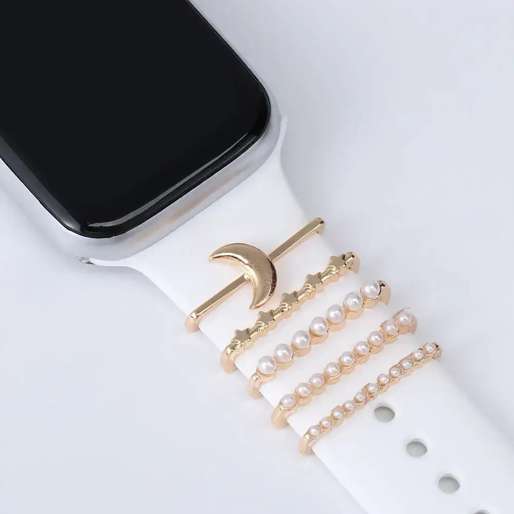 Decorative metal charms on a white Apple Watch band, adding elegance and style for smartwatch lovers.