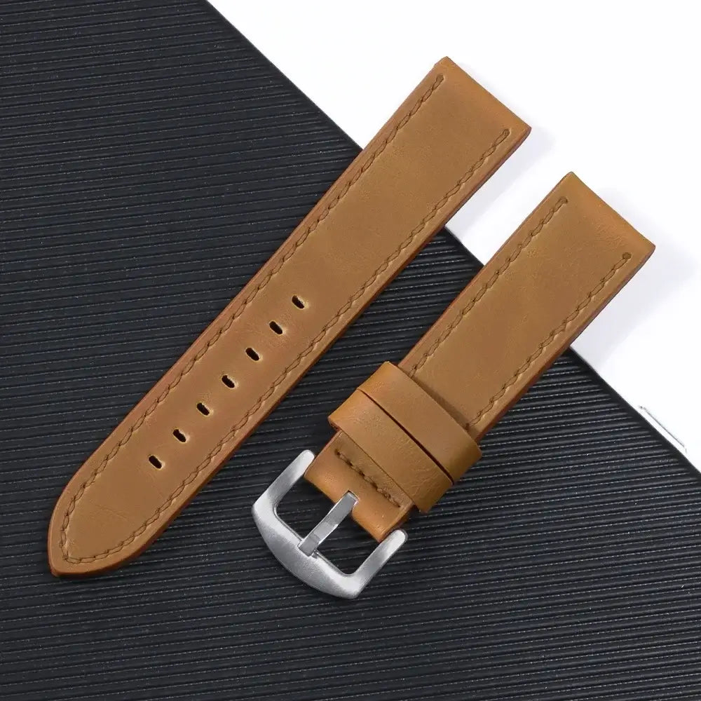 Suunto leather watch band in tan color with silver buckle, showcasing sleek design and durability for smartwatches.