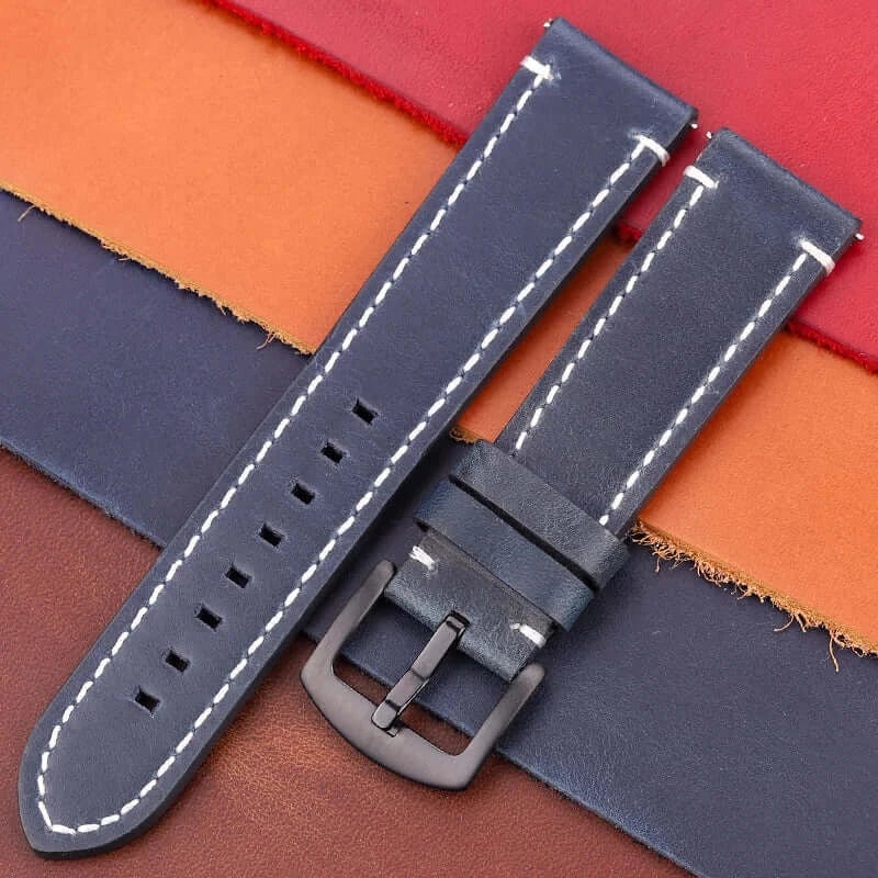 Leather Suunto watch band in navy blue with white stitching, displayed on various leather textures.