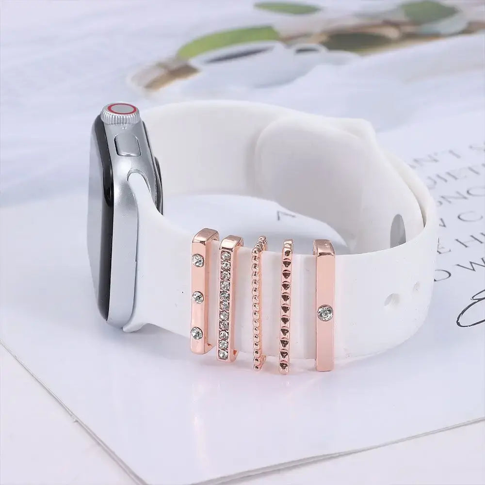 Decorative metal charms on a white Apple Watch band, adding style and personalization to your wrist.
