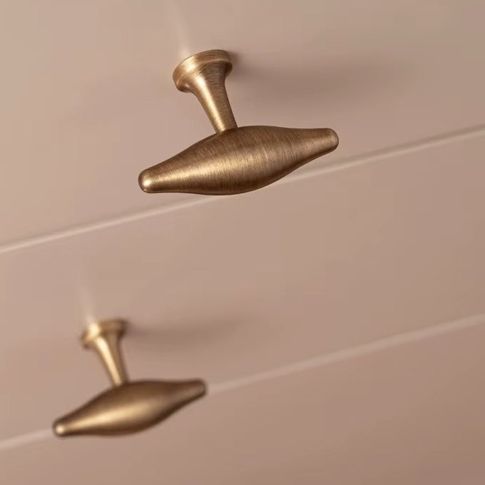 Arched olive-shaped solid brass T-bar cabinet knob in antique brass
