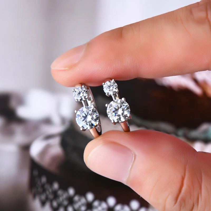 Graduated Two-Stone Moissanite Hoop Earrings in Sterling Silver — Silver pair held for scale