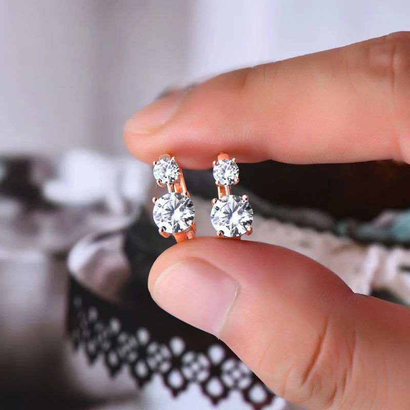 Graduated Two-Stone Moissanite Hoop Earrings in Sterling Silver — Rose Gold-Tone pair held for scale