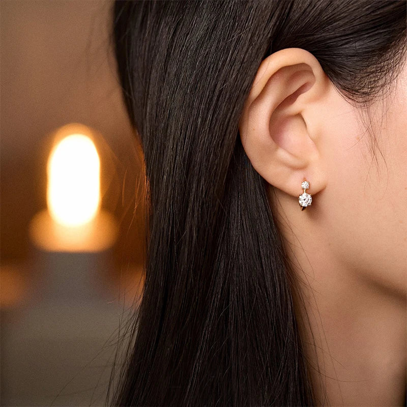 Graduated Two-Stone Moissanite Hoop Earrings in Sterling Silver — Hoop earrings styled on the ear