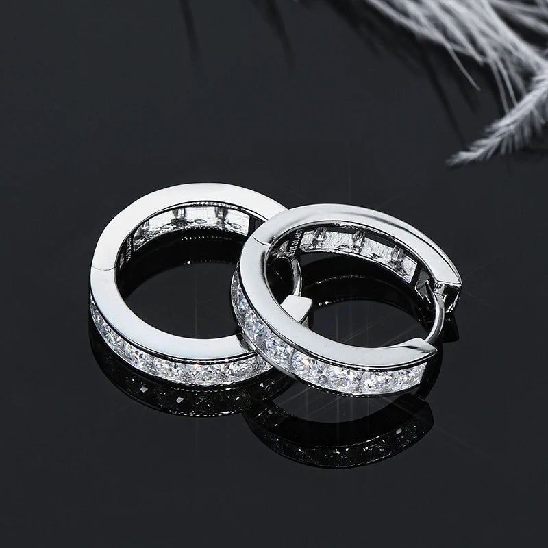Moissanite Channel-Style Huggie Hoop Earrings in Silver — Silver pair on reflective surface
