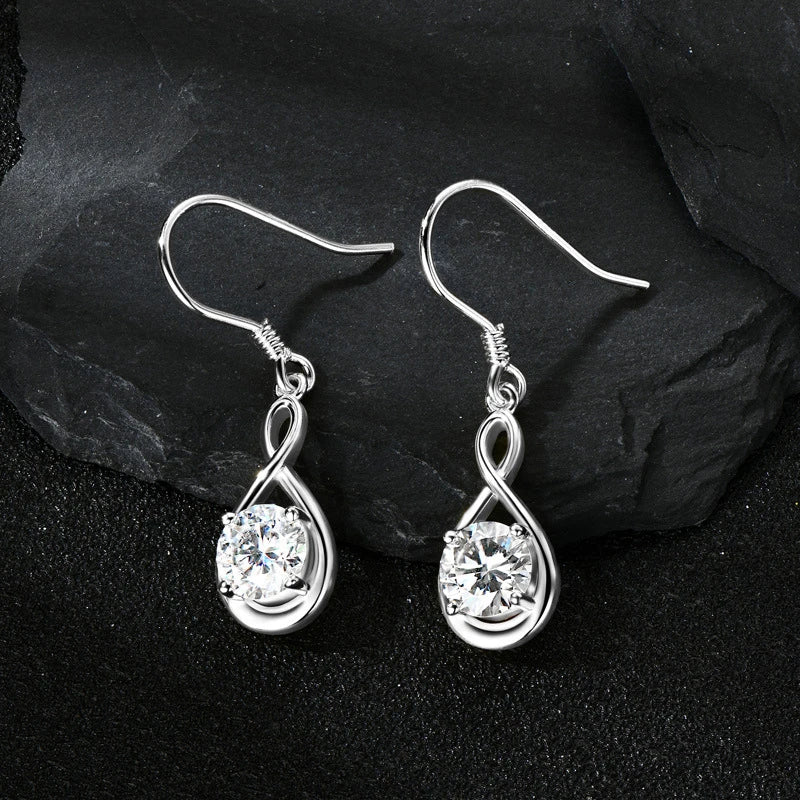Twisted Teardrop Moissanite Hook Earrings in Silver — Silver pair on dark surface