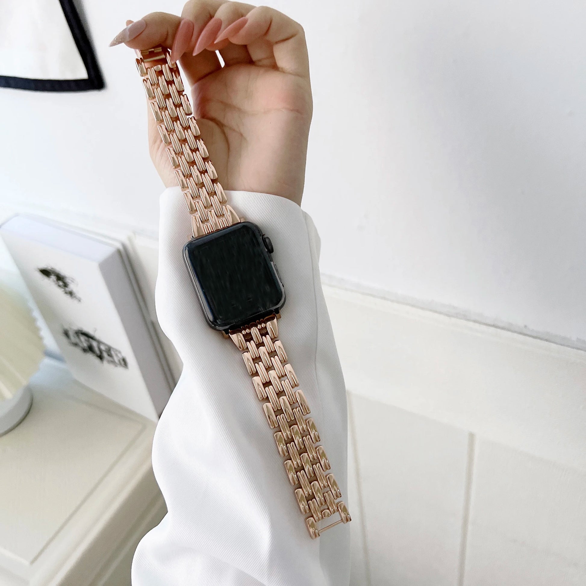 Elegant Apple Watch with luxury diamond design stainless steel band, worn on a hand in a bright setting.