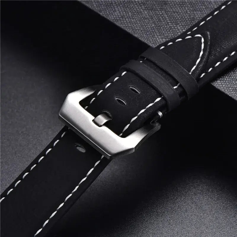 Close-up of a durable leather Suunto watch band with a sleek metal buckle and contrasting white stitching.