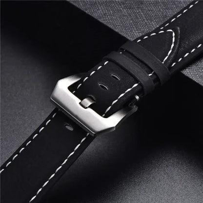 Close-up of a durable leather Suunto watch band with a sleek metal buckle and contrasting white stitching.