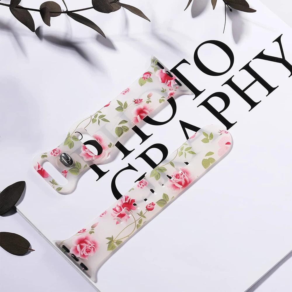 Apple Watch silicone strap featuring a floral design, resting on a photo backdrop, showcasing style and comfort.
