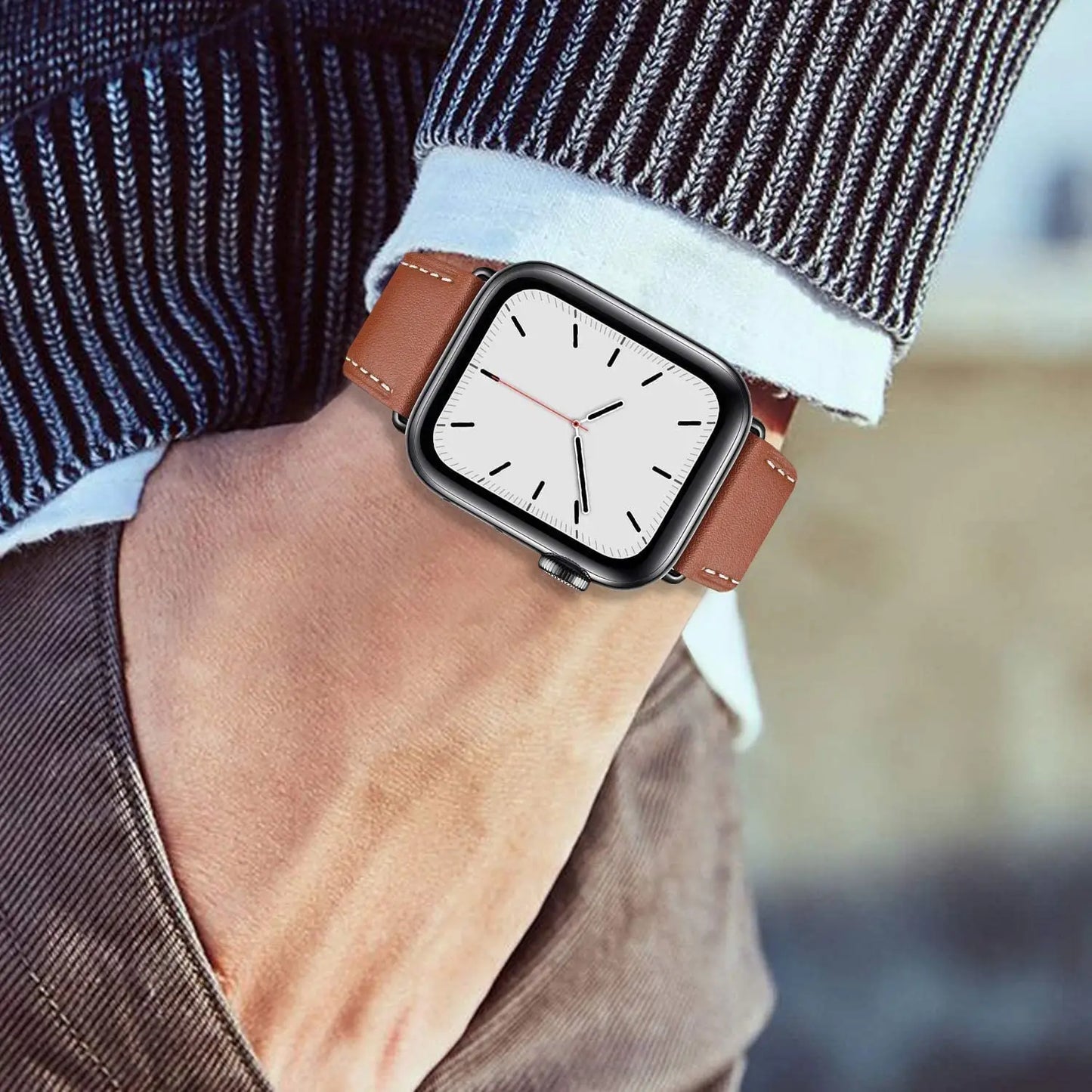 Close-up of a stylish wrist wearing a smartwatch with a brown fabric band against a casual outfit.