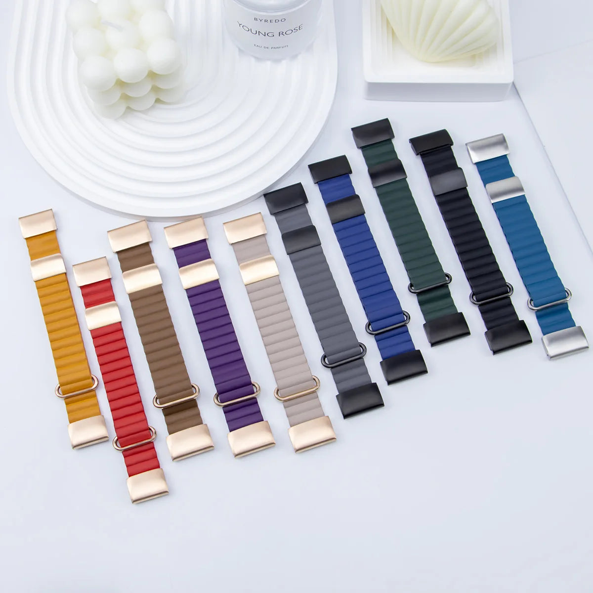 Collection of colorful smartwatch bands in various styles and colors, including gold and silver clasps on a white background.