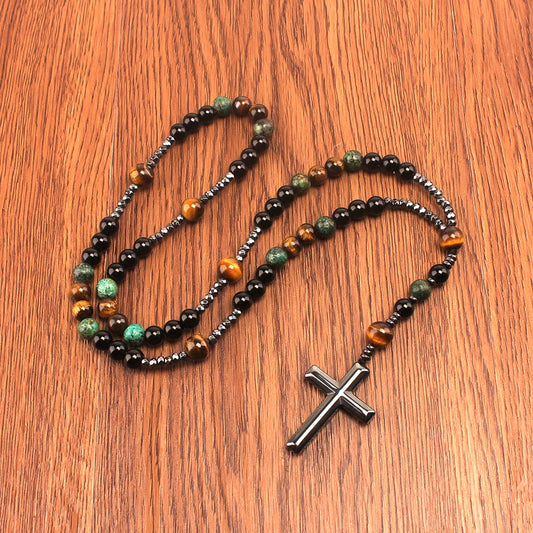 Tiger's eye and African turquoise bead cross necklace on wooden surface