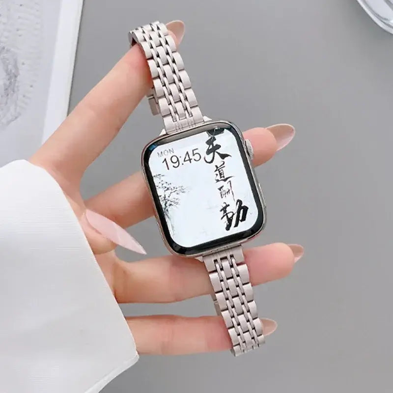 Silver multi-link Apple Watch band held in hand