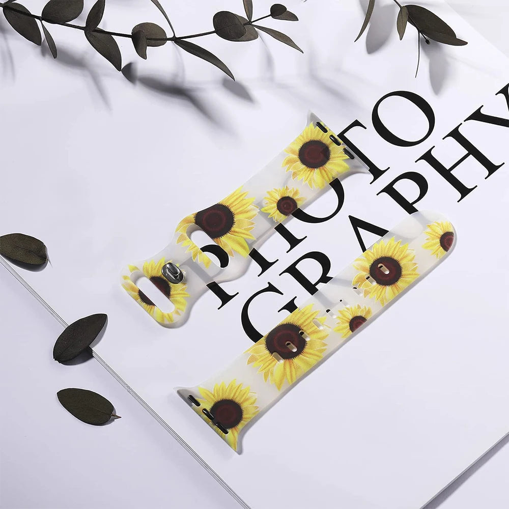 Apple Watch silicone strap with sunflower floral design on a photography backdrop.