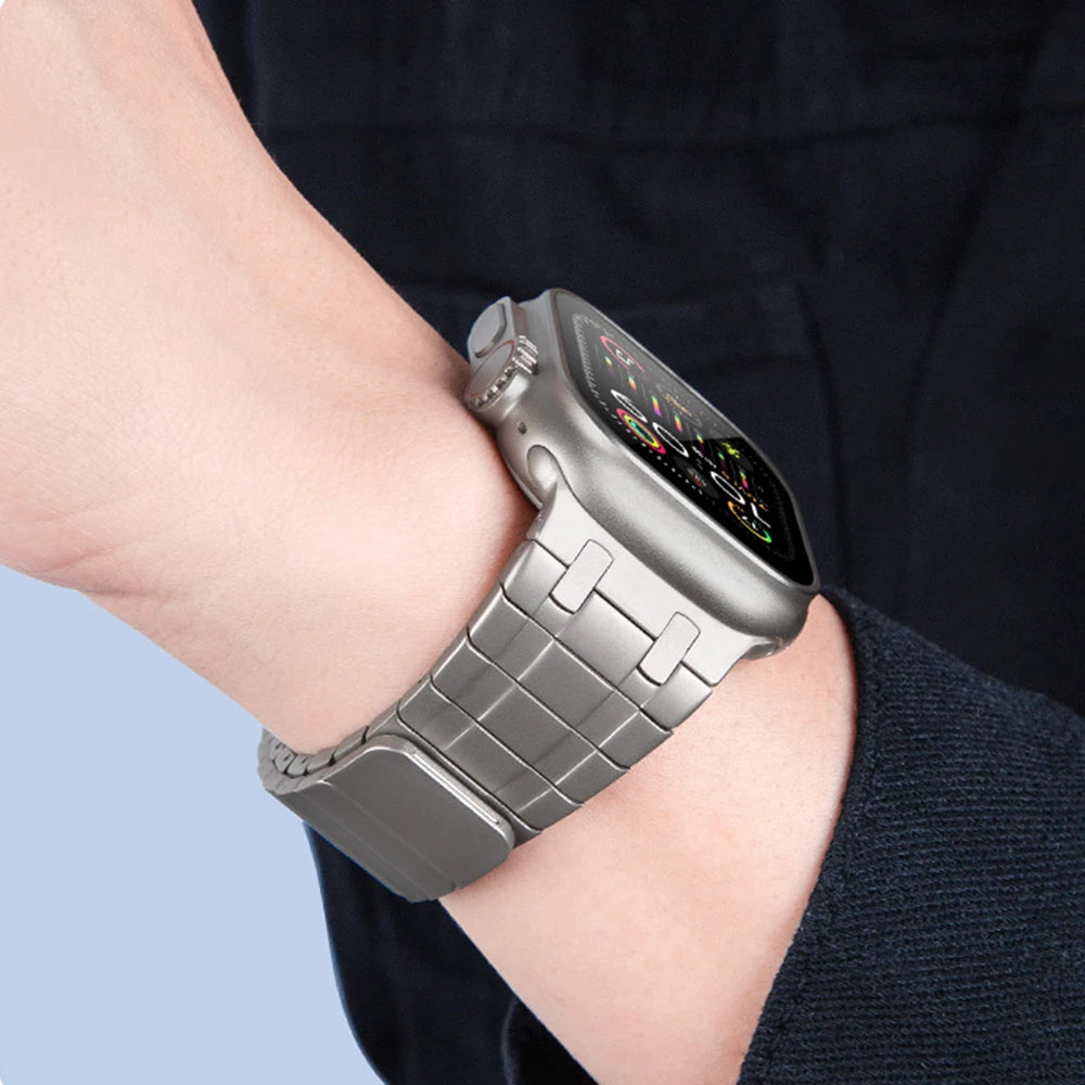 Apple Watch with magnetic stainless steel band in premium titanium color on a wrist, showcasing style and comfort.