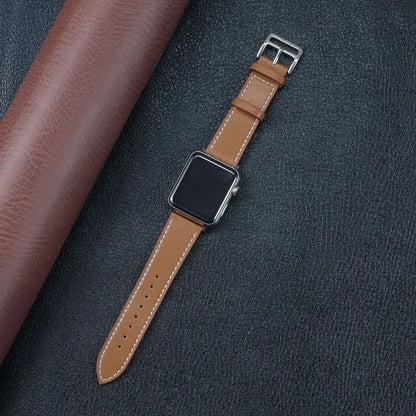 Brown leather Apple Watch band on a black leather background, showcasing style and comfort.