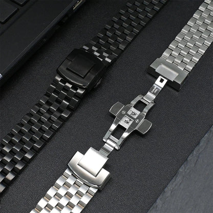 Garmin stainless steel strap and black band on a surface, showcasing durable smartwatch replacement options.