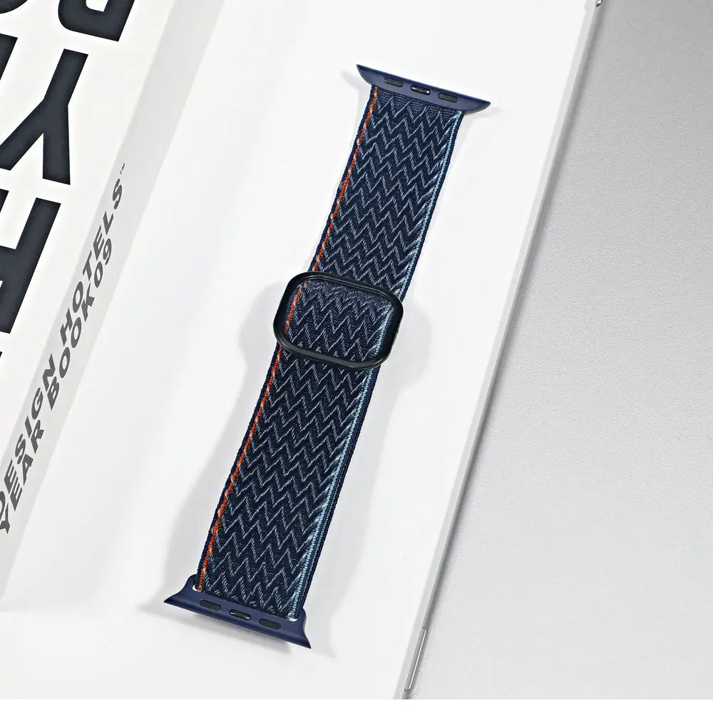 Apple Watch nylon sport loop strap in navy with red stitching, offering comfort and breathability.