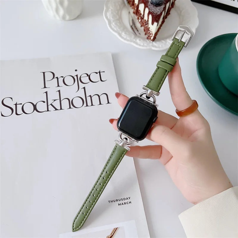 Apple Watch with green genuine leather strap on a table next to a coffee cup and notebook.