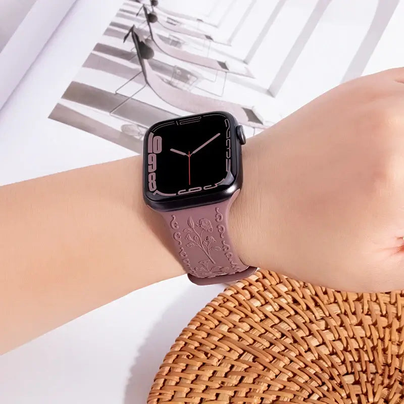 Mauve botanical engraved Apple Watch band worn on wrist