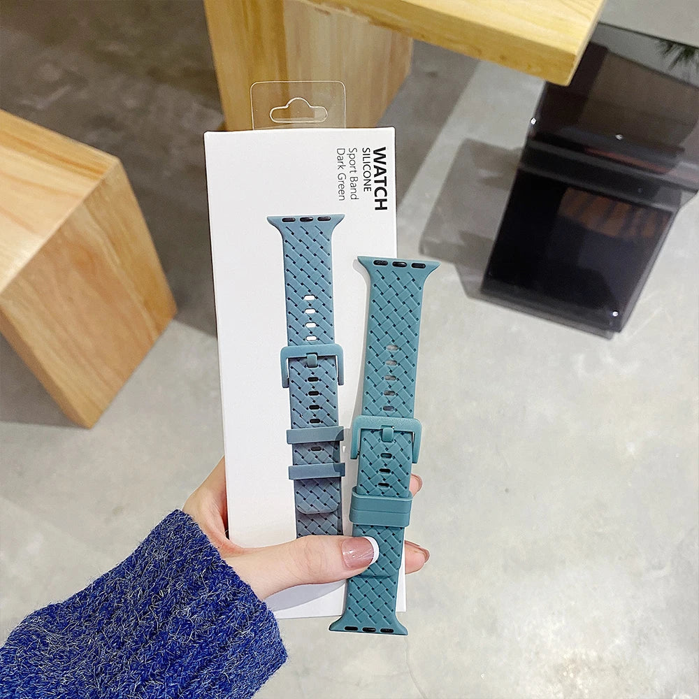 Apple Watch silicone strap in teal color displayed in packaging, showcasing soft, comfortable rubber design.