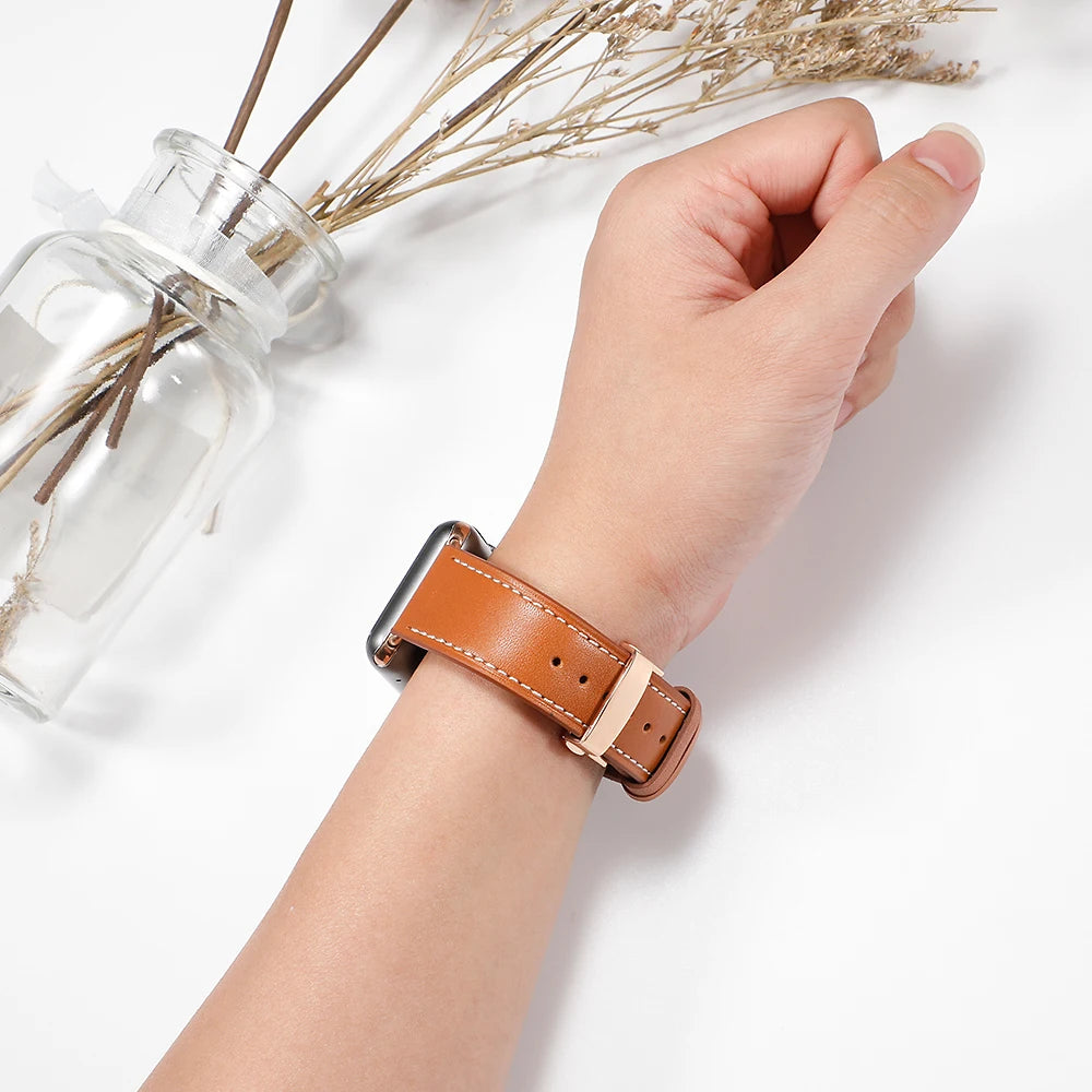 Tan stitched leather band worn on a wrist for Apple Watch