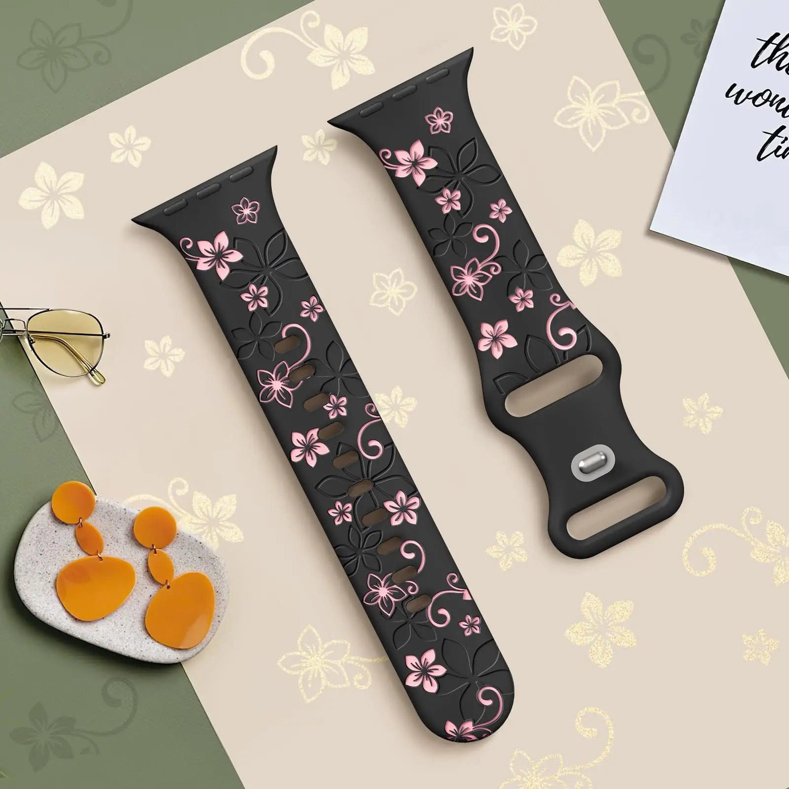 Apple Watch silicone strap with floral designs in black and pink, featuring a stylish and comfortable fit.