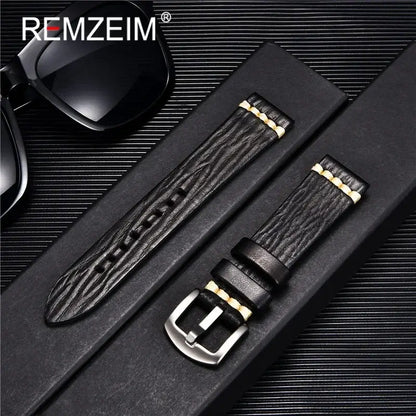 Stylish black textured leather watch band with gold accents, perfect for Suunto watches, showcased with sunglasses.