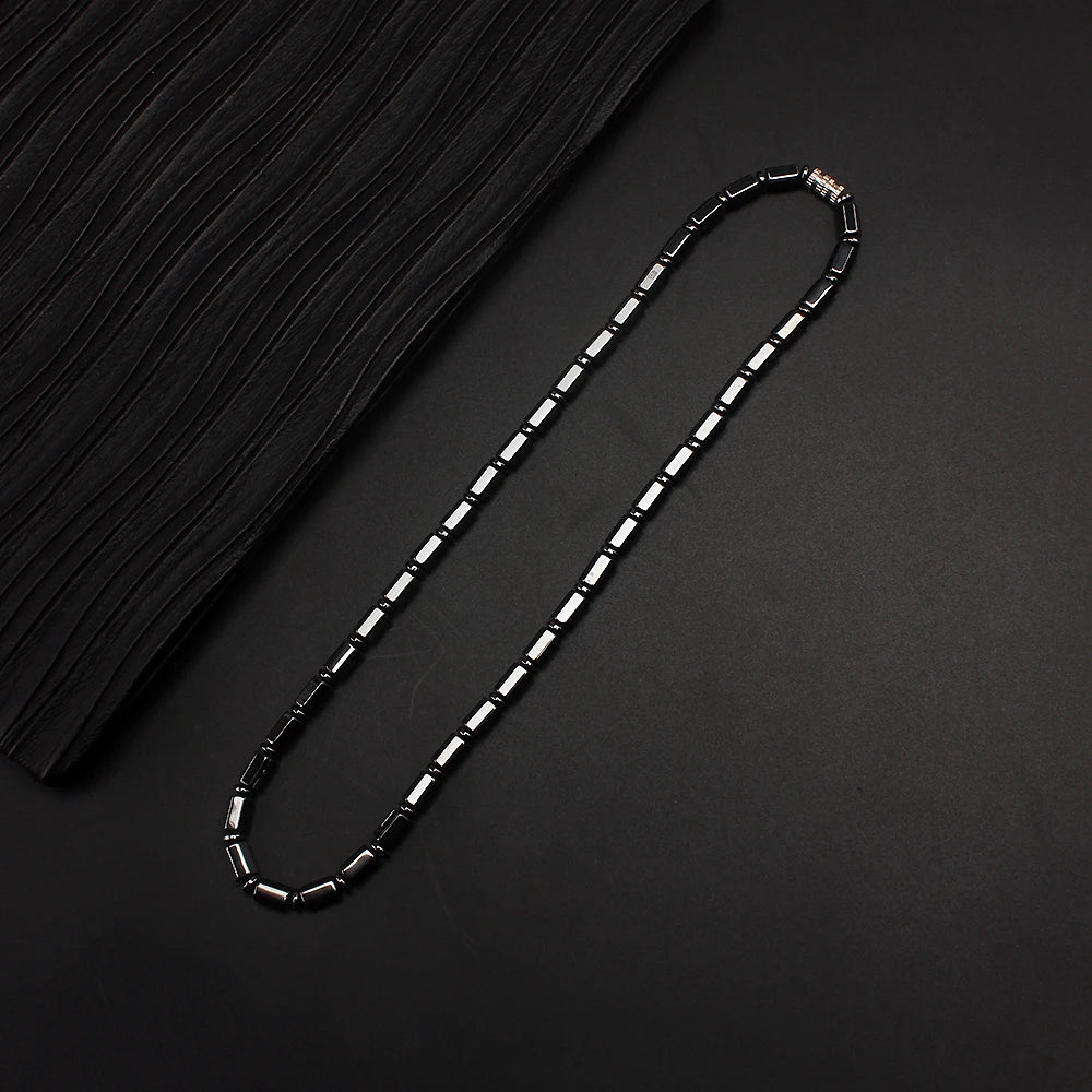 Simulated hematite bamboo bead necklace laid flat on black fabric