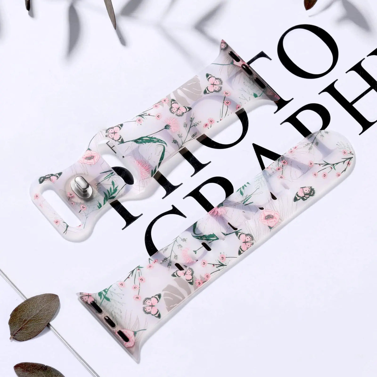 Pink floral and butterfly strap displayed flat for Apple Watch