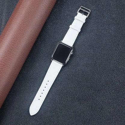 Apple Watch with a white fabric band, resting on a textured surface, showcasing its stylish and comfortable design.