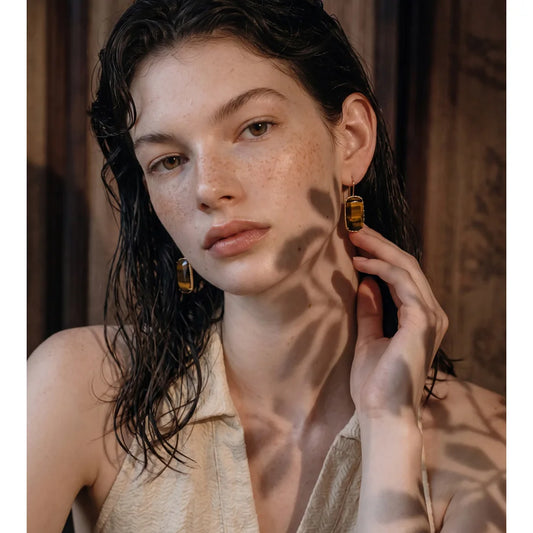 Woman wearing tiger's eye rectangle drop earrings