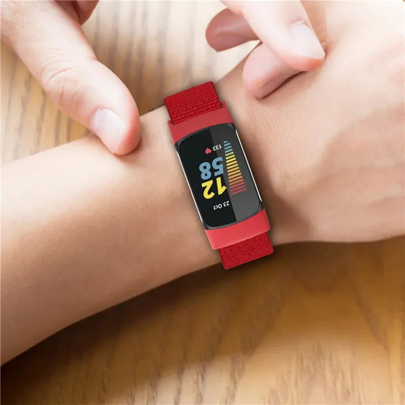Fitbit Charge 5 with red Elastic Nylon Loop band on wrist, showcasing smartwatch functionality and comfort.