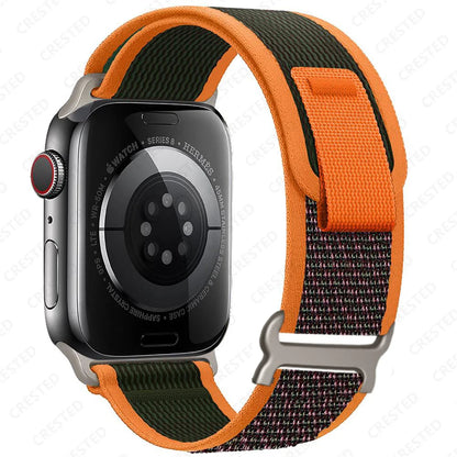 Apple Watch featuring a Trail Loop nylon strap in vibrant orange and green, designed for durability and comfort.