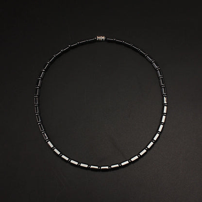 Simulated hematite bamboo bead necklace laid in a circle