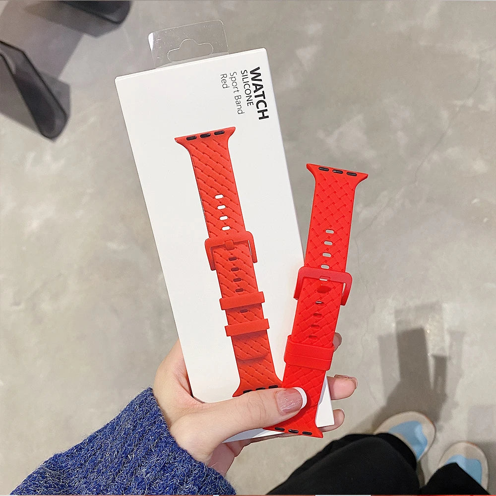 Apple Watch silicone strap in red packaging, showcasing a flexible, comfortable rubber band design.